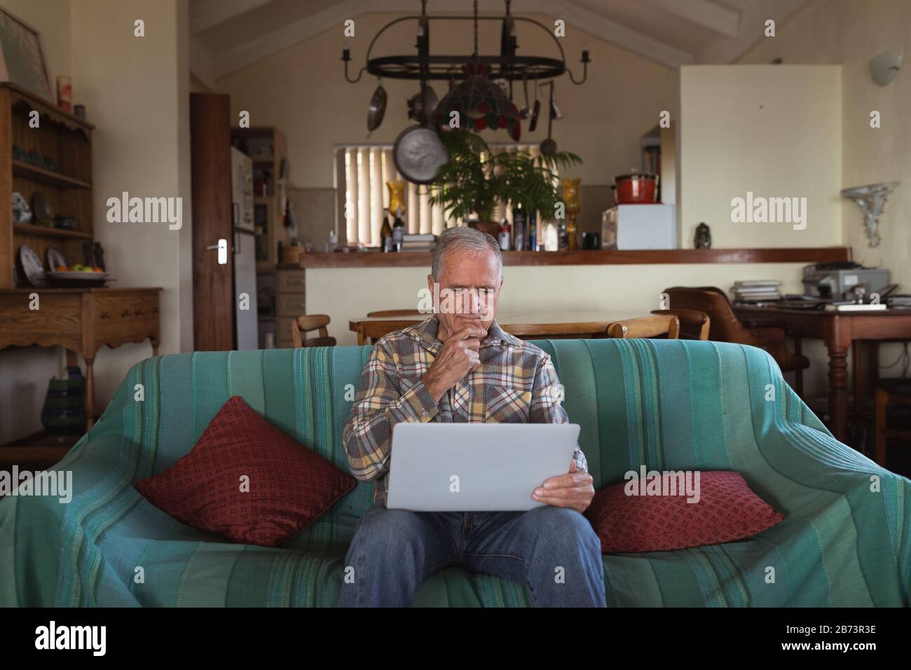 Senior man using laptop at home Stock Photo