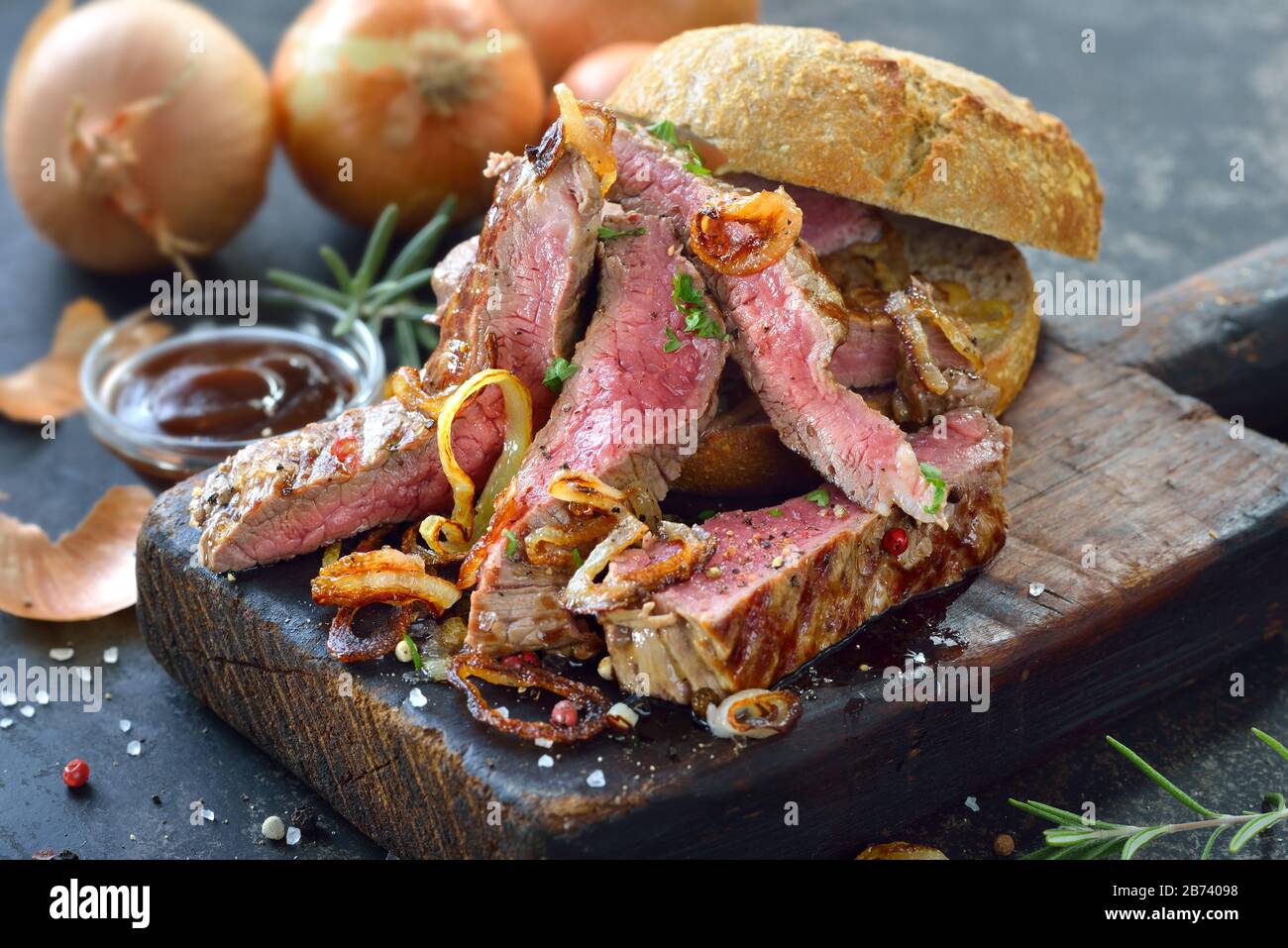 Burger with juicy meat strips of beef loin steak and fried onion rings