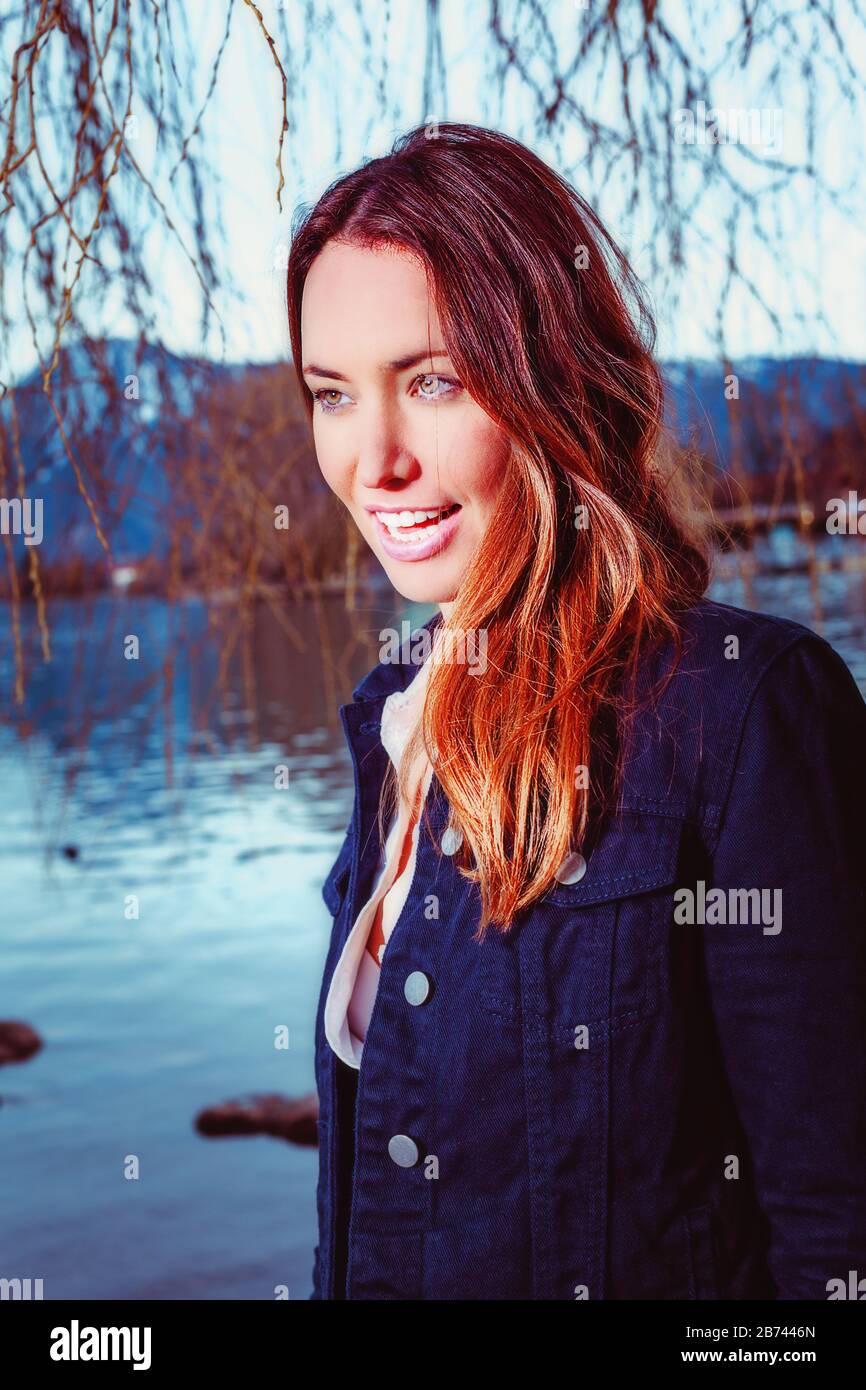 Portrait of a young brunette woman at the lake Stock Photo - Alamy