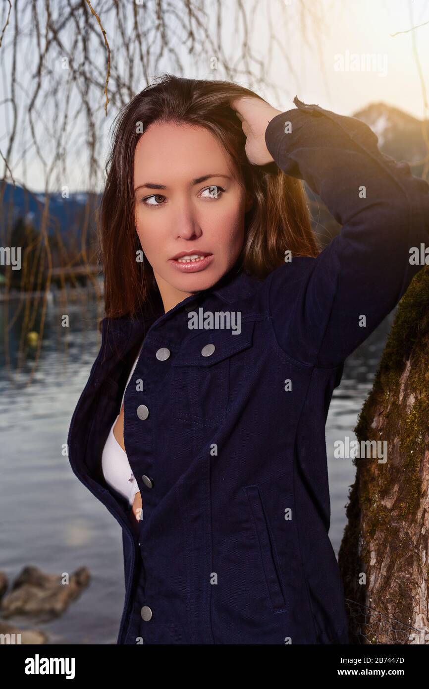 Portrait of a young brunette woman at the lake Stock Photo - Alamy