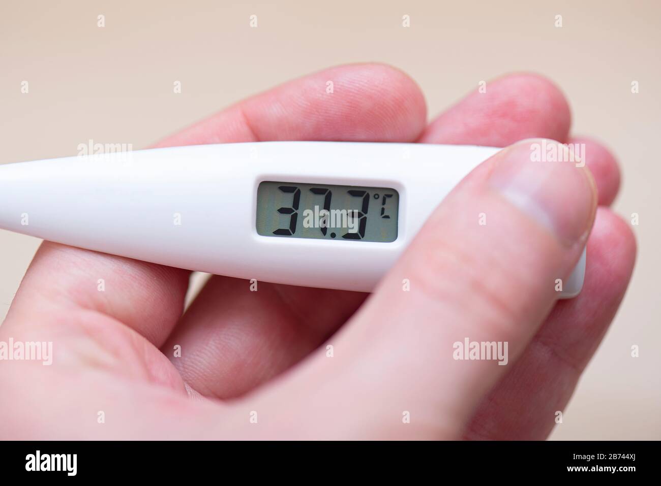Close-up Thermometer showing high Temperature 37 and Pills on Table Stock Photo