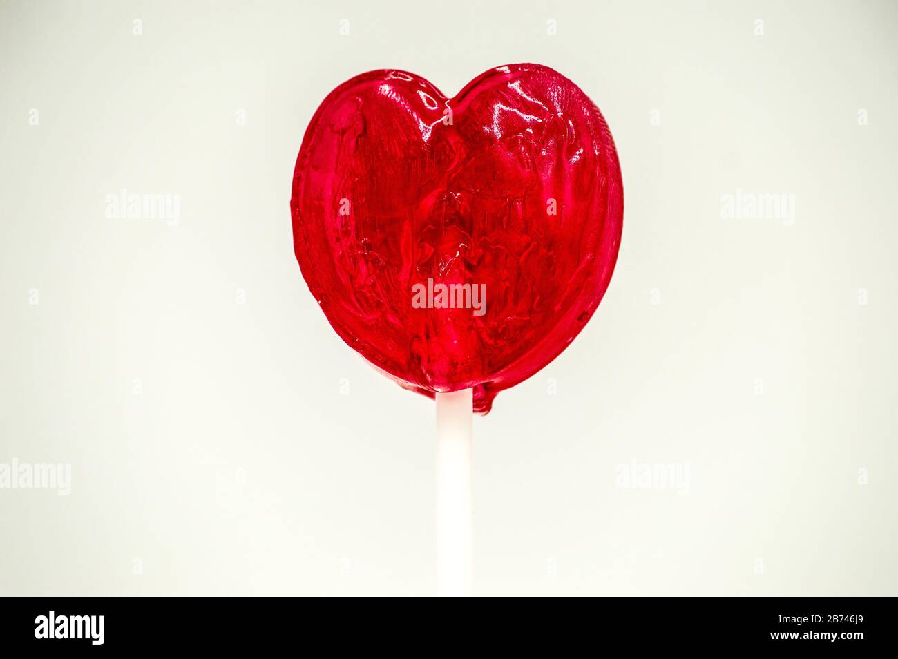 Heart shaped red lollipop on a white background Stock Photo - Alamy
