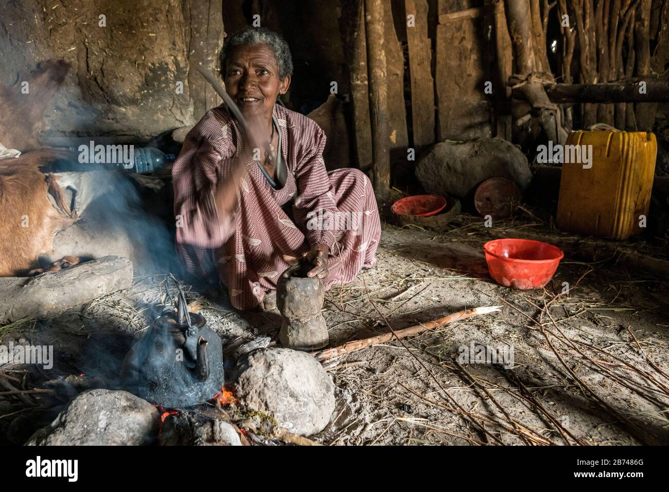 Villager pounding coffee beans using a mortar and pestle, Simien Mountains, Ethiopia Stock Photo