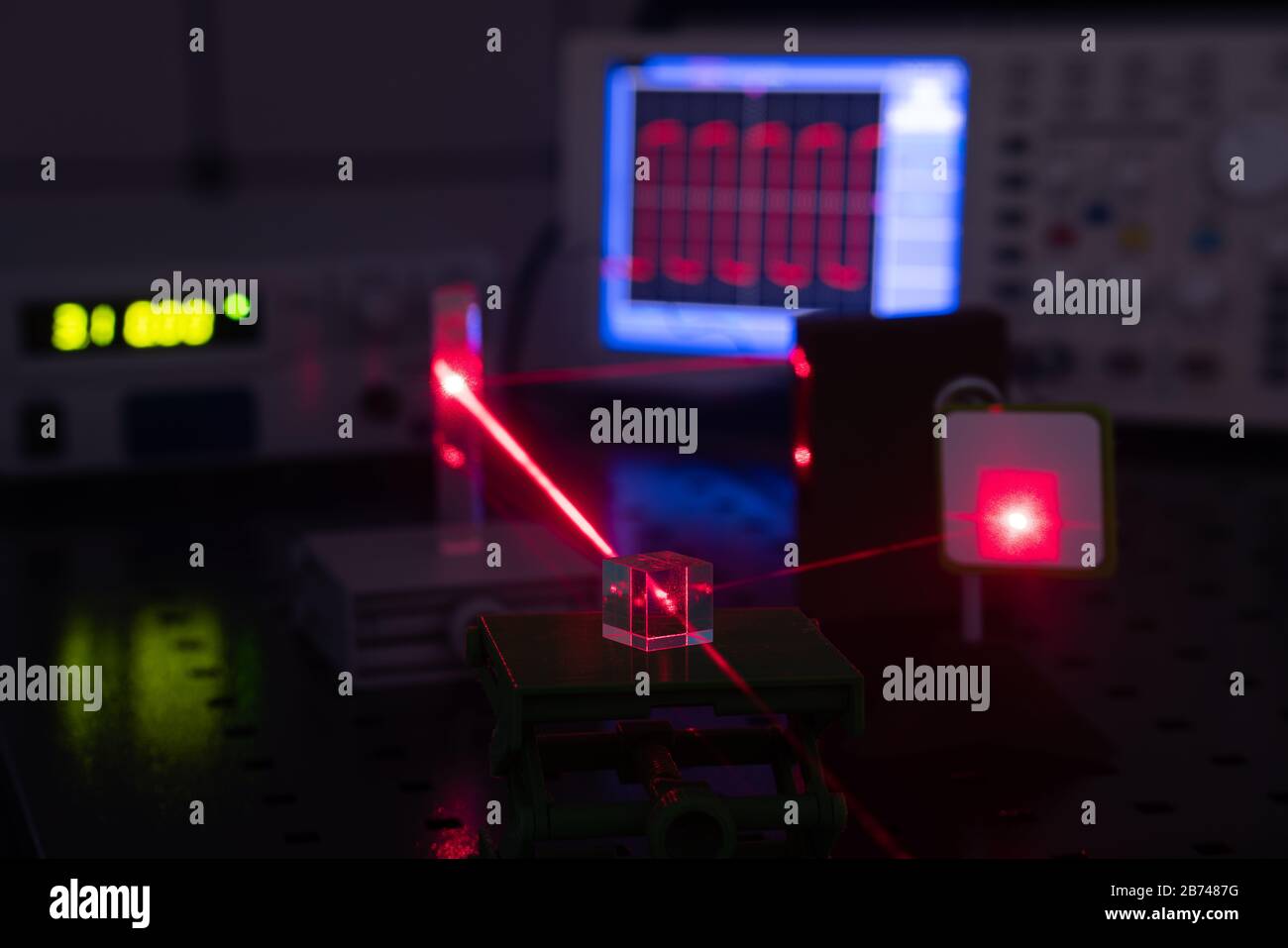 Experiment in optic lab with laser device. Red laser on optical table