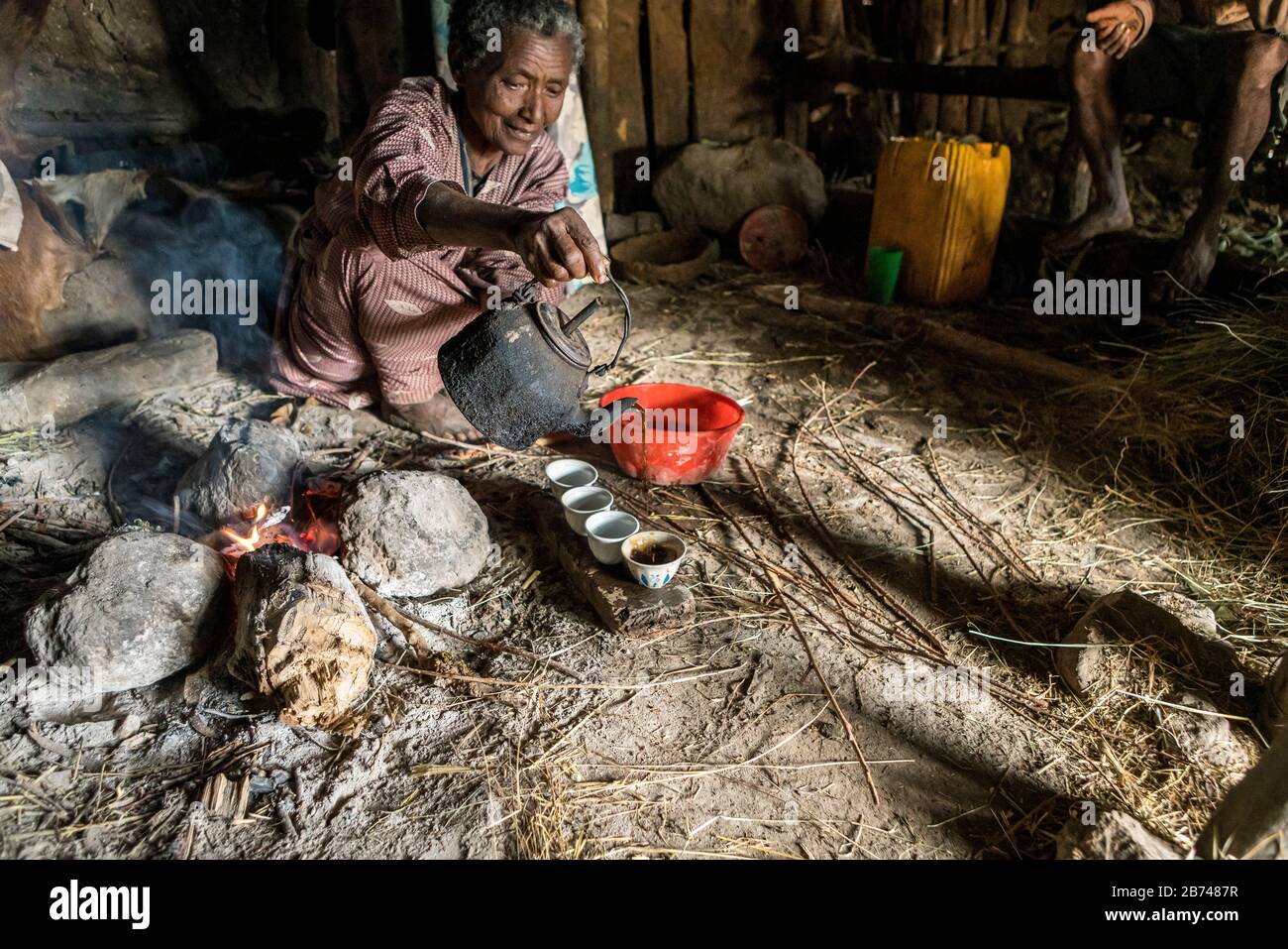 Villager pouring just-roasted coffee, Simien Mountains, Ethiopia Stock Photo