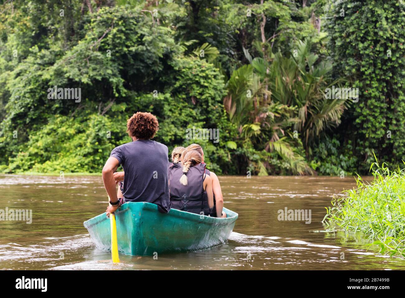 People exploring a wild nature area by rowing boat. Ecotourism concept. Tortuguero national park. Costa Rica. Stock Photo