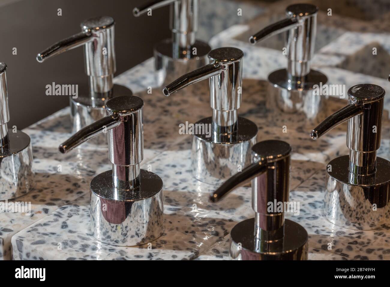 Close up of soap dispensers with metallic head & marble textured body. Symbol for hygiene, sanitary industry, desinfection, washing hands. Stock Photo