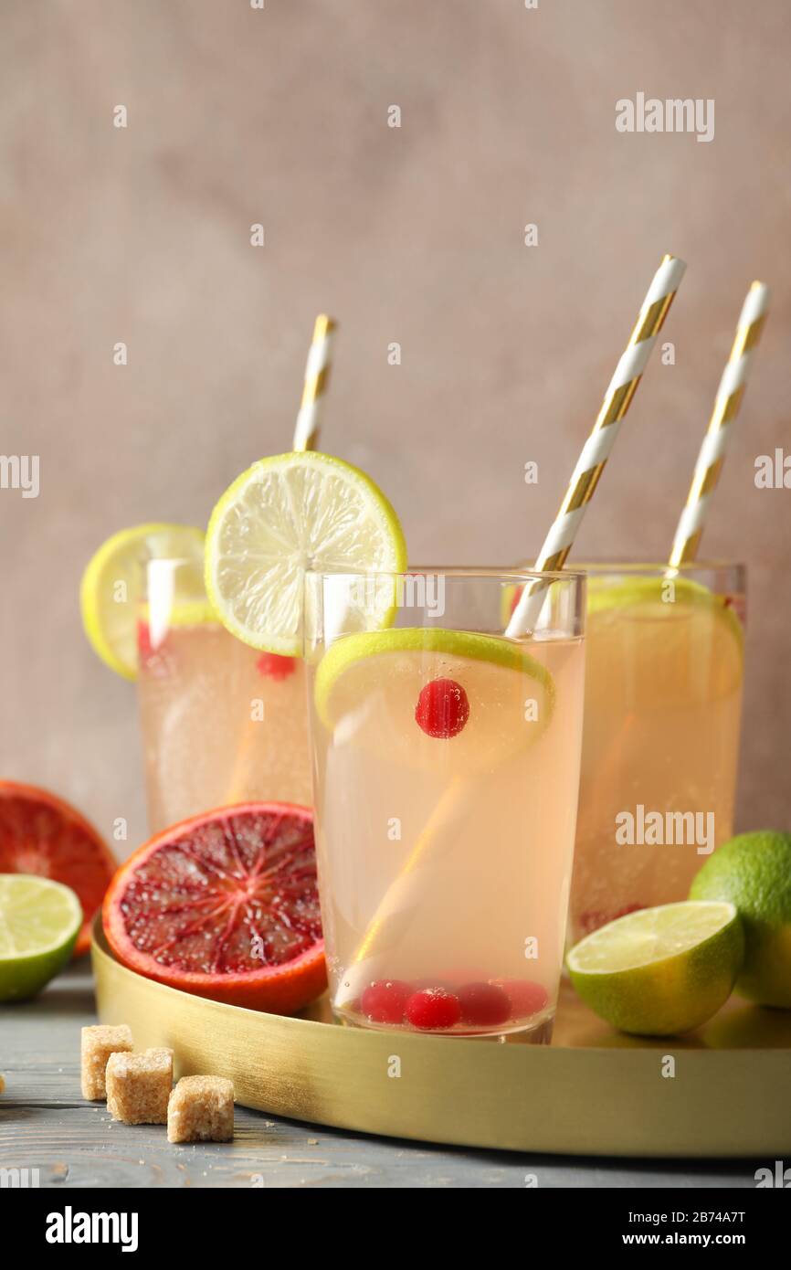 Glass jars with lemonade and ingredients against brown background