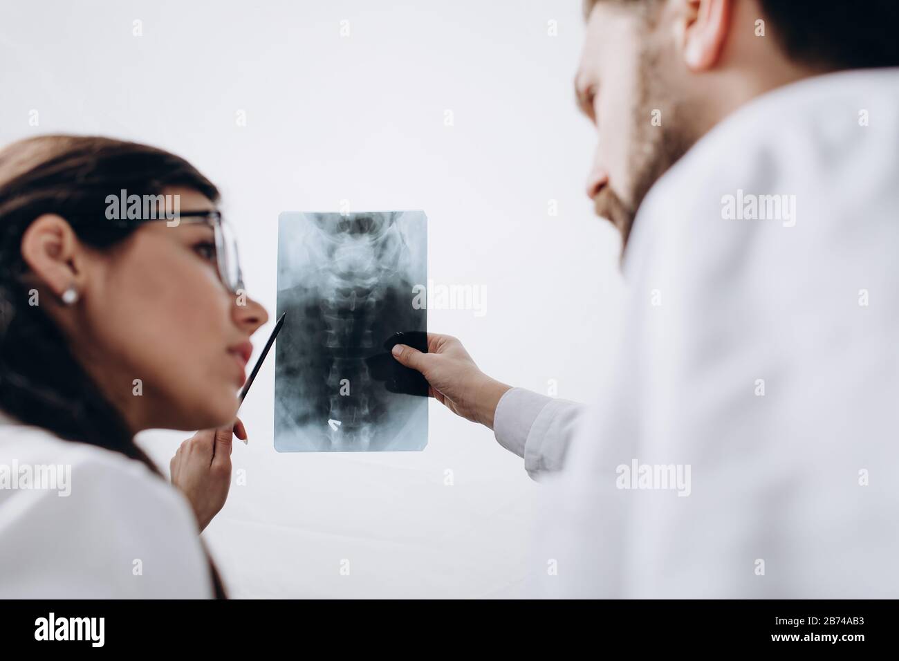 Physicians in White Coats Examining Spinal Radiography Image Stock