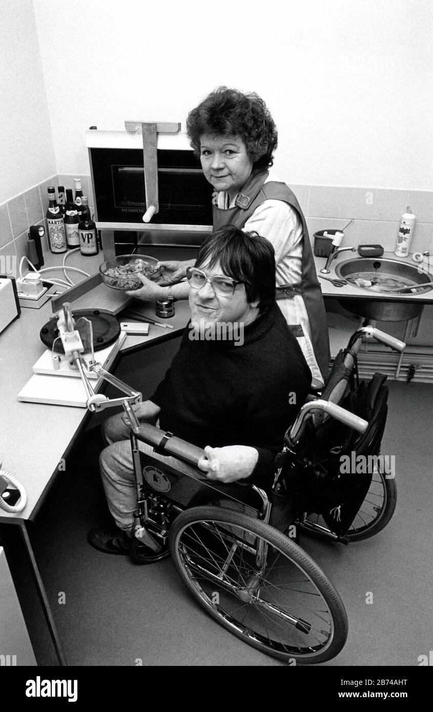 Disabled man at home with carer, UK 1989 Stock Photo
