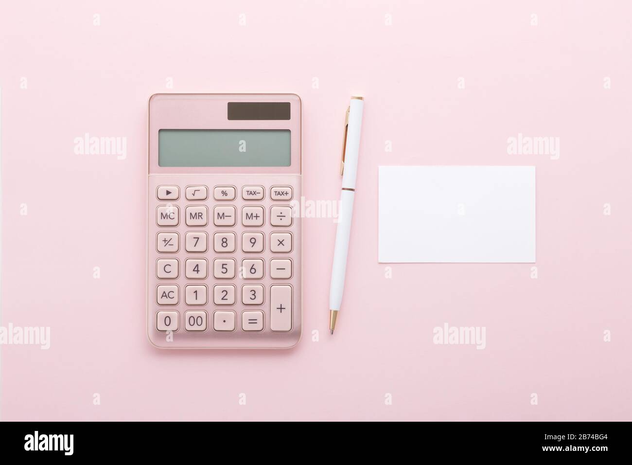Rose gold calculator with pen and business card on pink background, flat lay Stock Photo