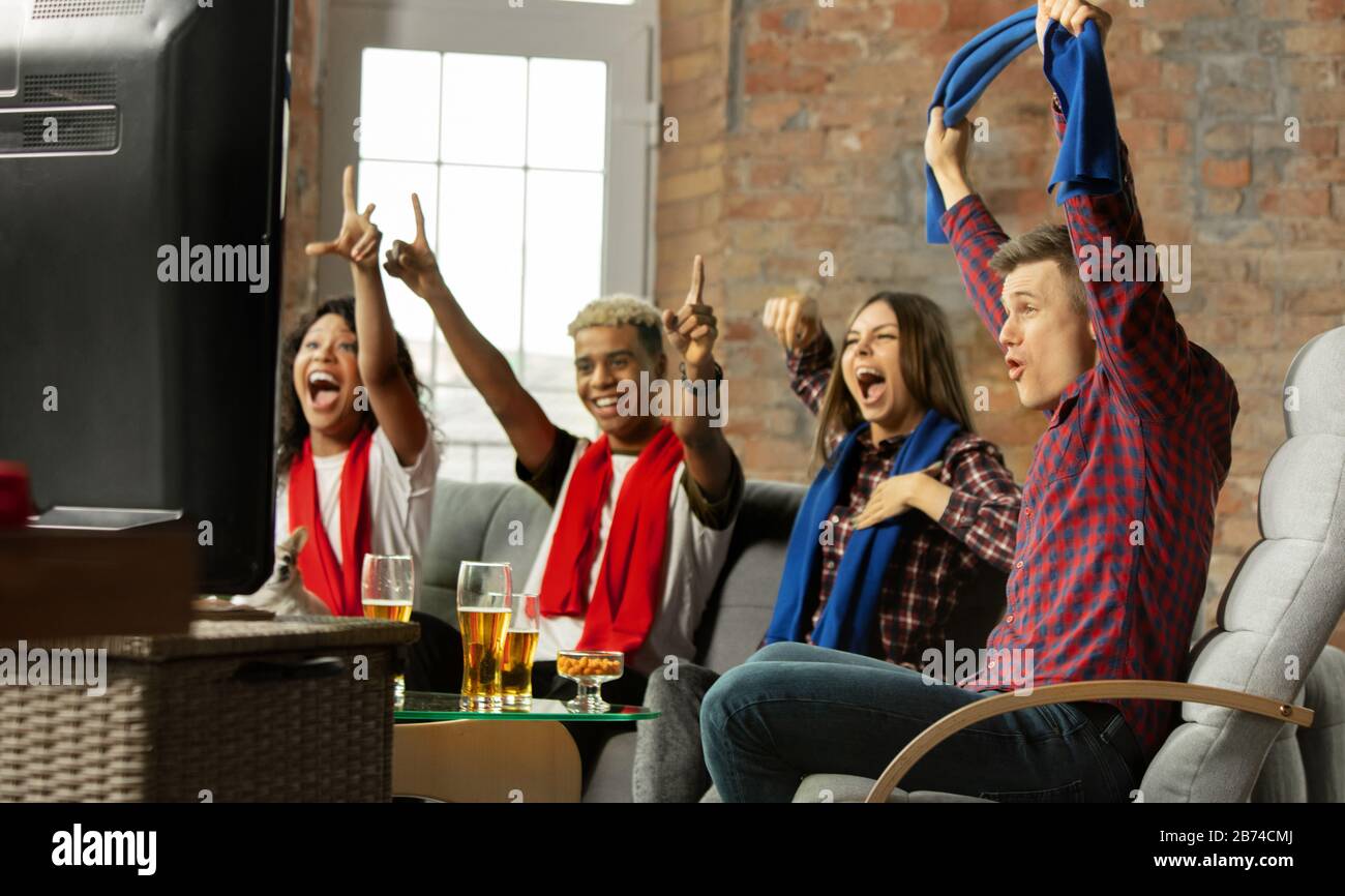 Winners. Excited people watching sport match, chsmpionship at home. Multiethnic group of friend, fans cheering for favourite national basketball, tennis, soccer, hockey team. Concept of emotions. Stock Photo