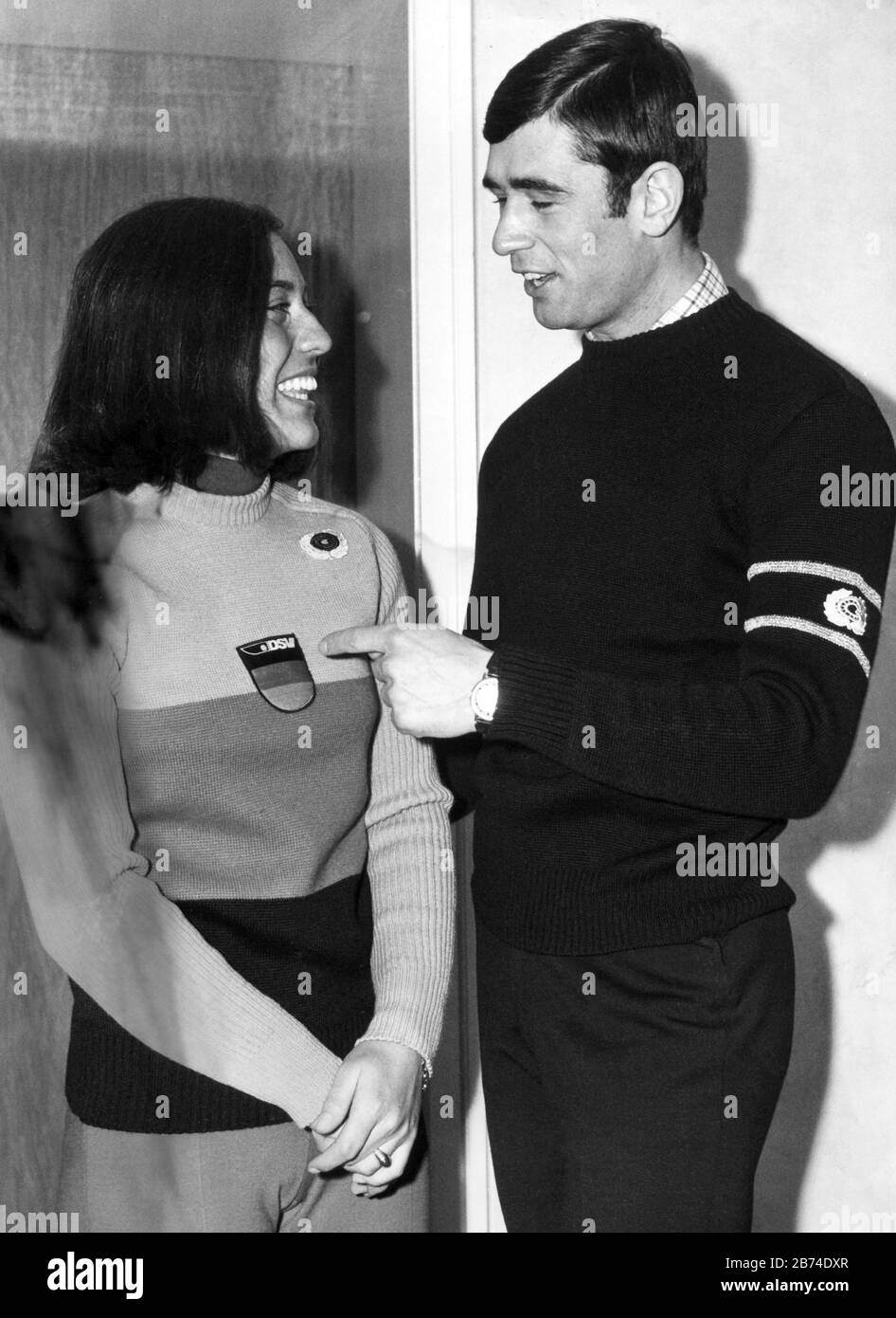 Rosi Mittermaier presents the new pullover of the German ski team in the national colours on 22 December 1970 in Munich. Speed skater Erhard Keller received a black sweater with gold stripes on his sleeves for his Olympic victory. | usage worldwide Stock Photo