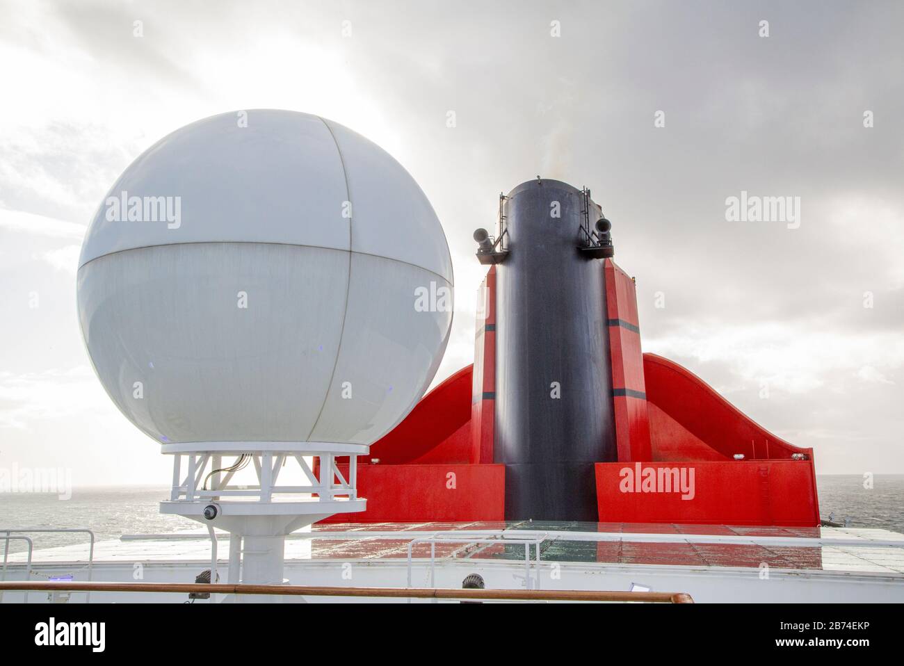 Crossing the Atlantic Ocean from Brooklyn to Southampton onboard the ocean liner Queen Mary 2. Markups for shuffleboard seen on the top deck of the QM 2. The red chimney houses the exhaust pipes from the four diesel engines that provide the propulsion. The QM 2 also has two gas turbines (near the stern) that provide power to four electrical generators (IEP - integrated electric propulsion) that provides economical cruising at low speed and enables sustained high speed. Stock Photo