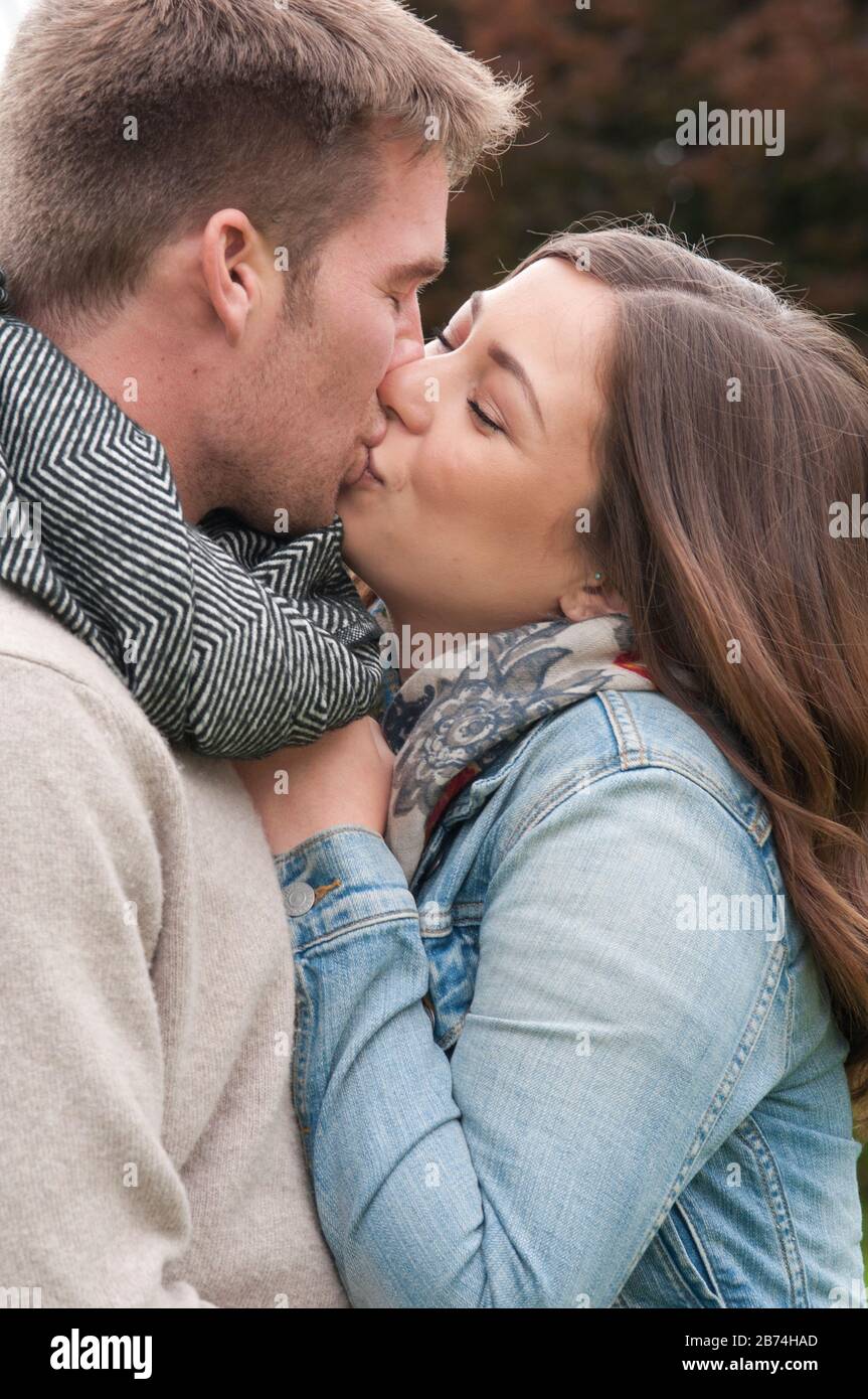 Young couple outdoors kissing and cuddling Stock Photo
