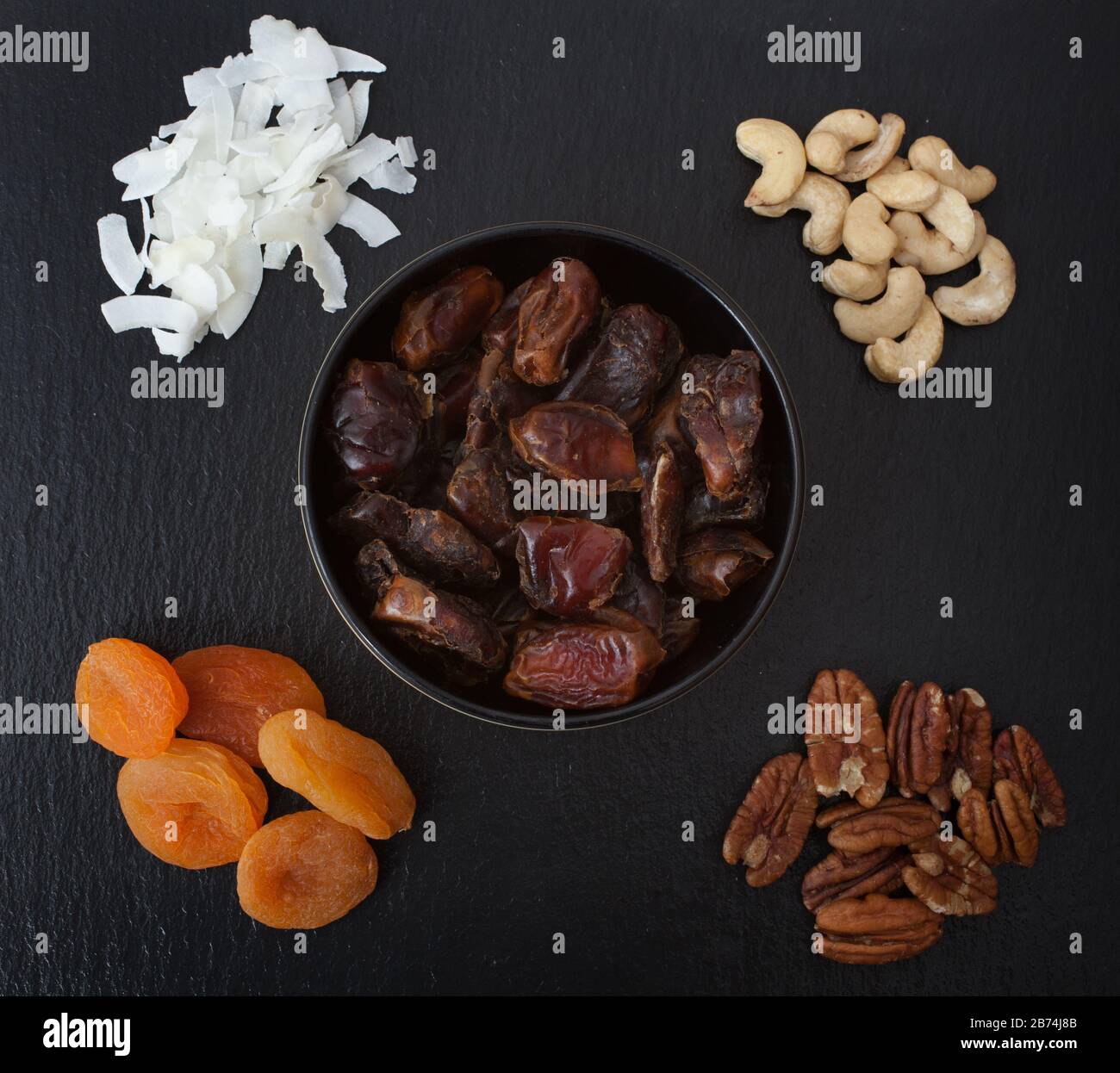 A studio photograph of dried fruits and nuts including coconut, cashew