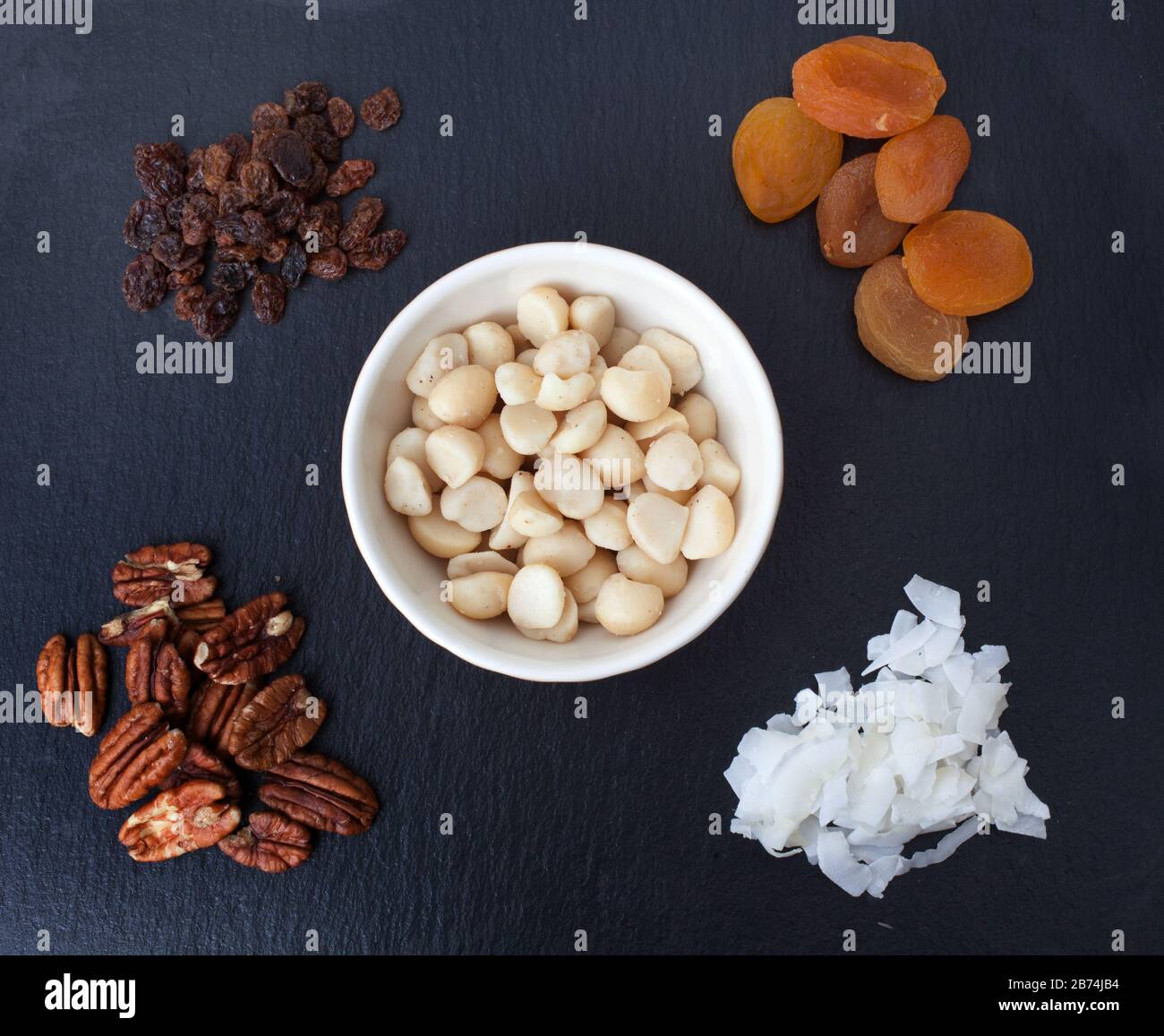 A selection of nuts and dried fruit including Apricots, Macadamia Nuts, Coconut Flakes, Sultanas and Pecans Stock Photo
