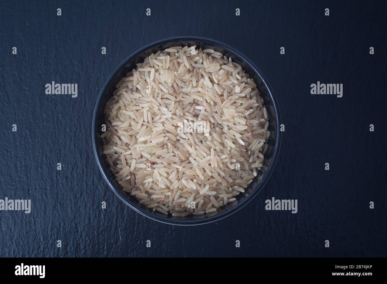 A bowl of uncooked brown rice Stock Photo