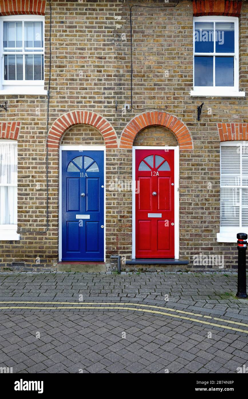 Two identical front doors, one red one blue, on old terraced houses on Brocas Street, Eton Berkshire England UK Stock Photo