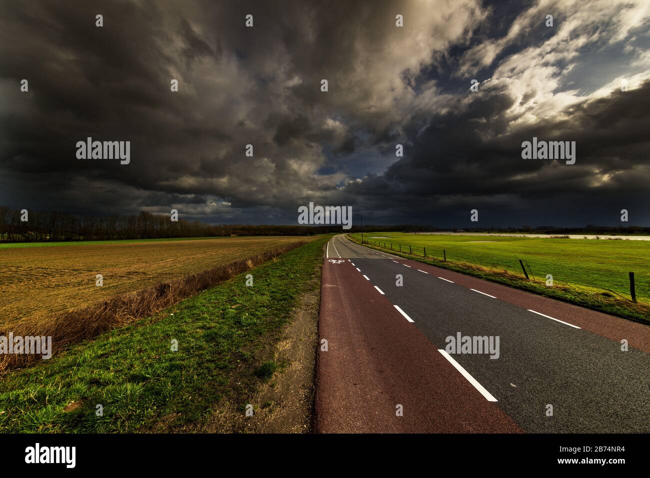 Highway in the valley under the dark cloudy sky in the countryside ...