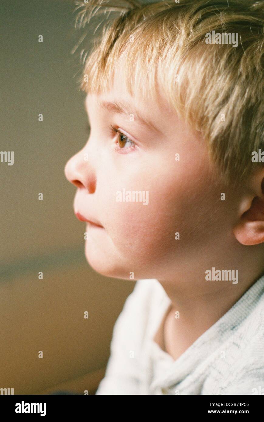 Little boy looking out the window, captured on film. Stock Photo