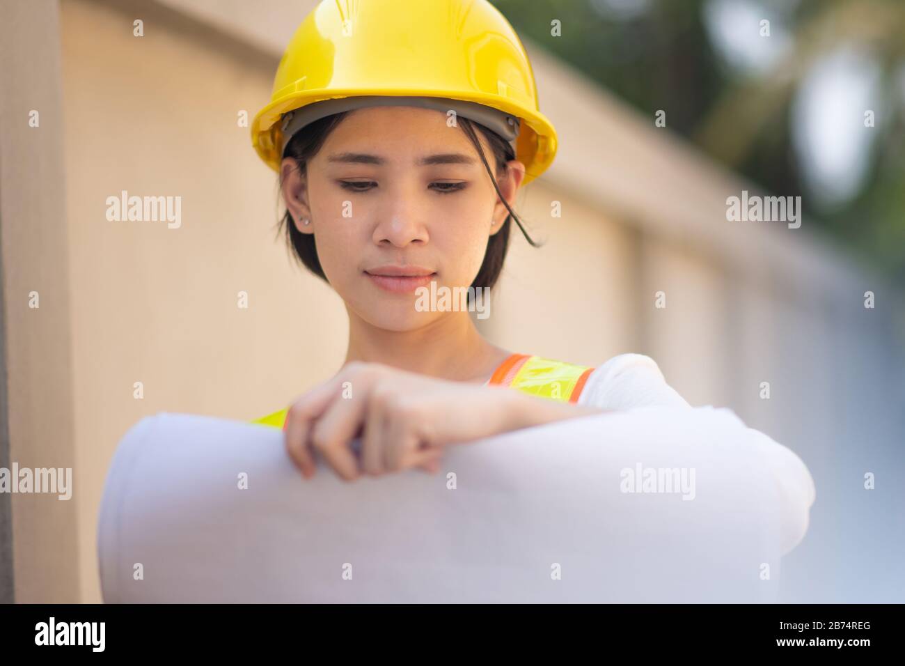 Woman Supervisor hard hat safety suit holding blueprint inspection