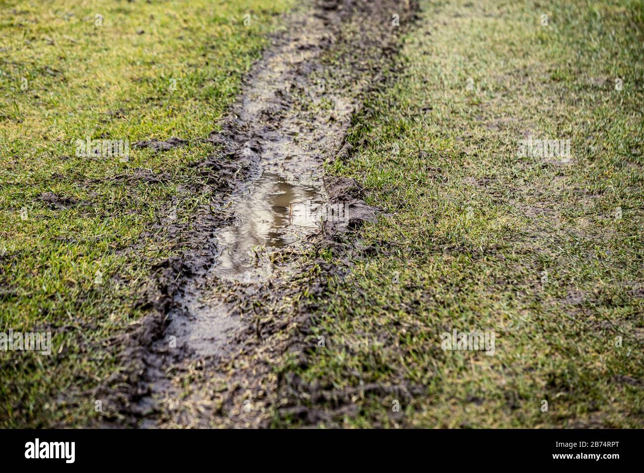 dirty mud road in winter with water on the road surface. sunny day with