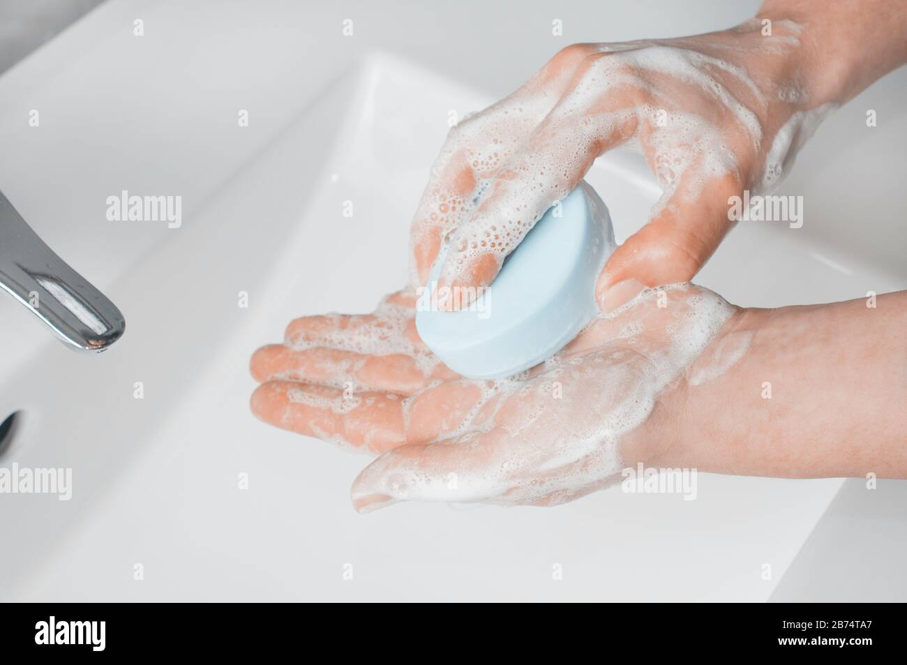 Hand washing techniques: woman soaping her hands with a bar of soap. Stock Photo