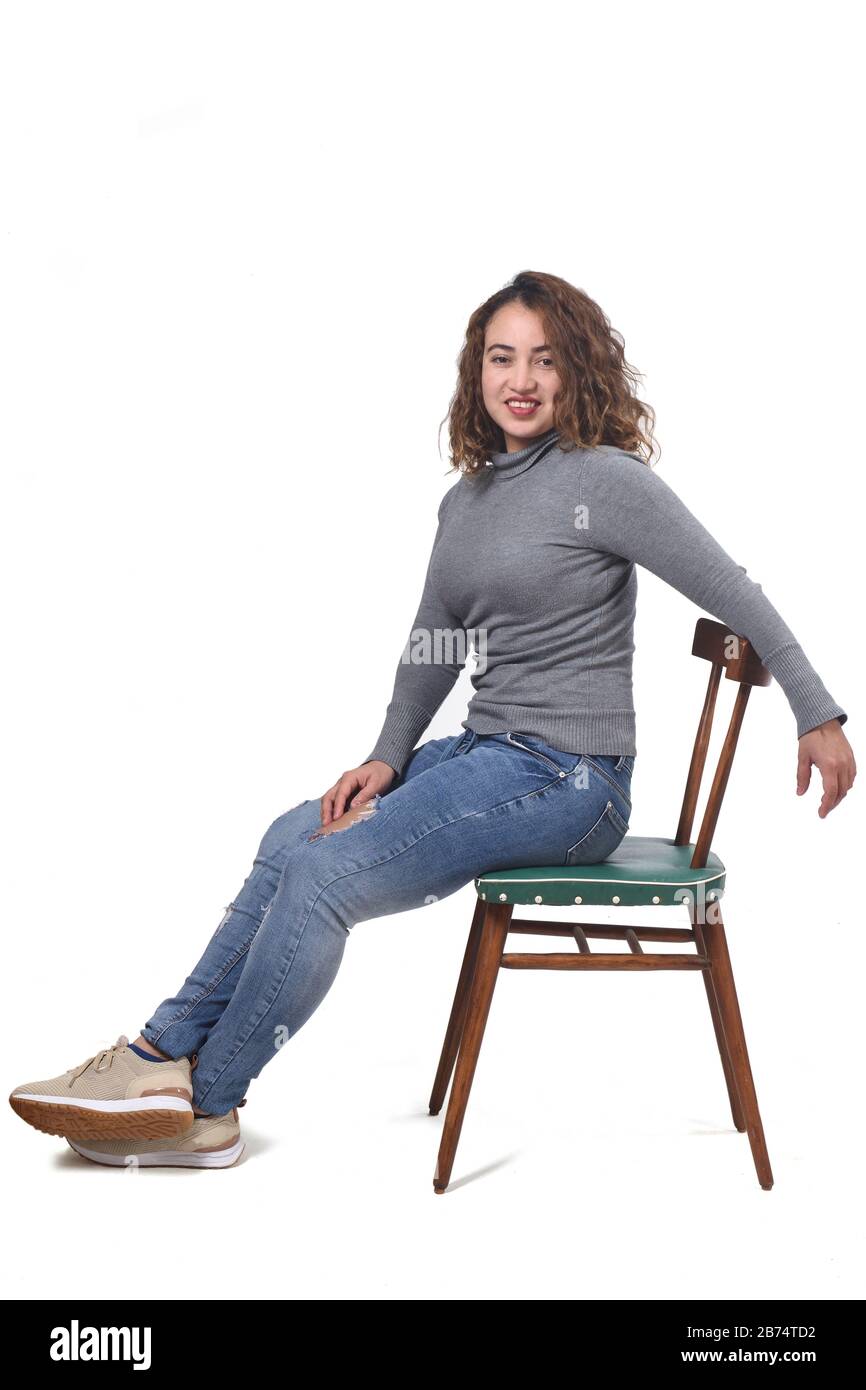 portrait of a woman sitting on a chair in white background, rear view of  the chair and looking at camera profile,relax Stock Photo - Alamy