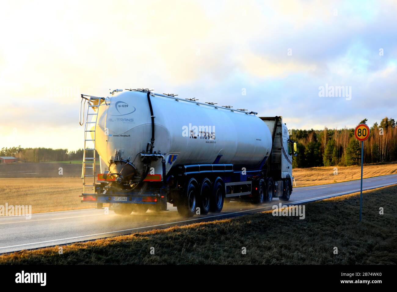 White Volvo semi tank truck RL-Trans at speed on wet highway 52 at sunset time in early spring, rear view. Salo, Finland. February 21, 2020. Stock Photo