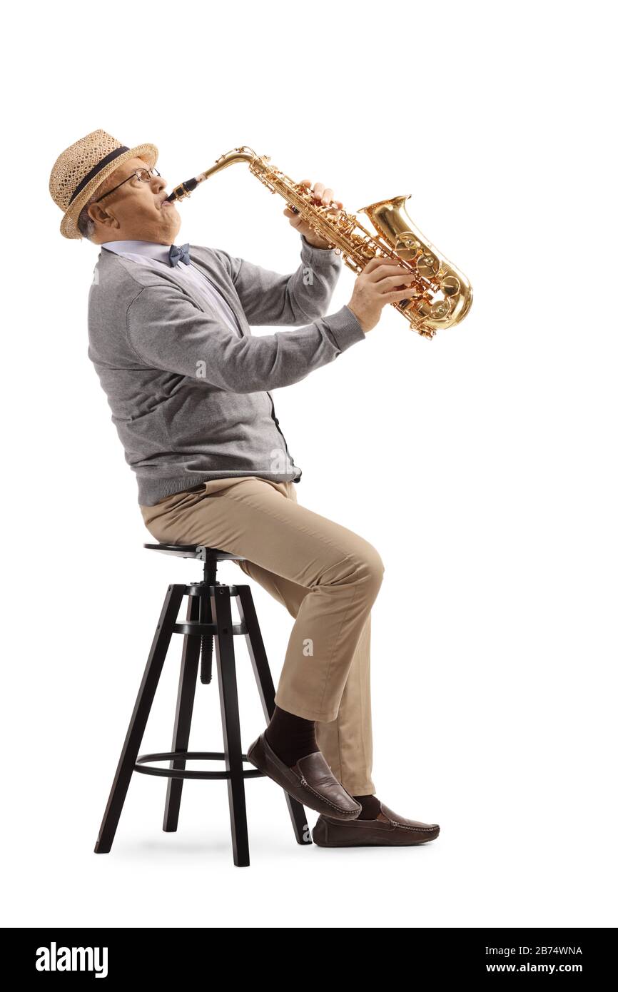 Elderly man sitting and playing a saxophone isolated on white background Stock Photo