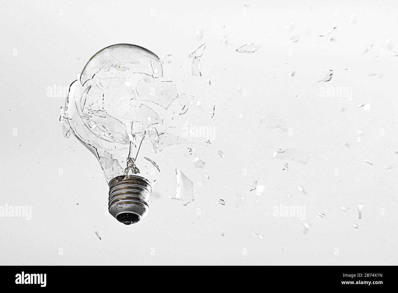 Closeup shot of a broken glass light bulb on a white background Stock Photo  - Alamy