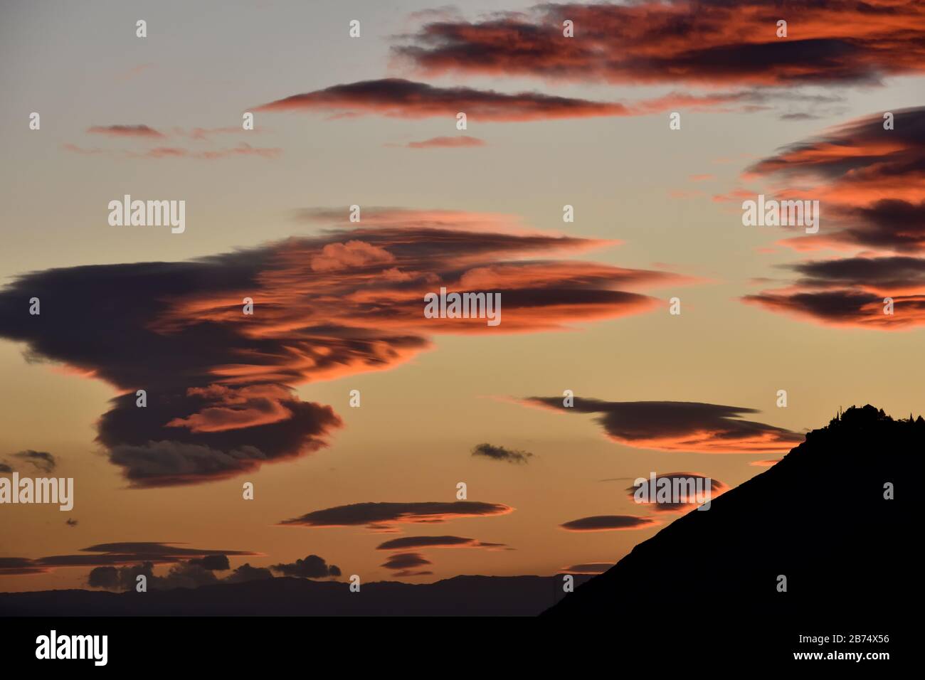 Nice lenticular clouds over Sierra Elvira in Granada at sunset Stock Photo
