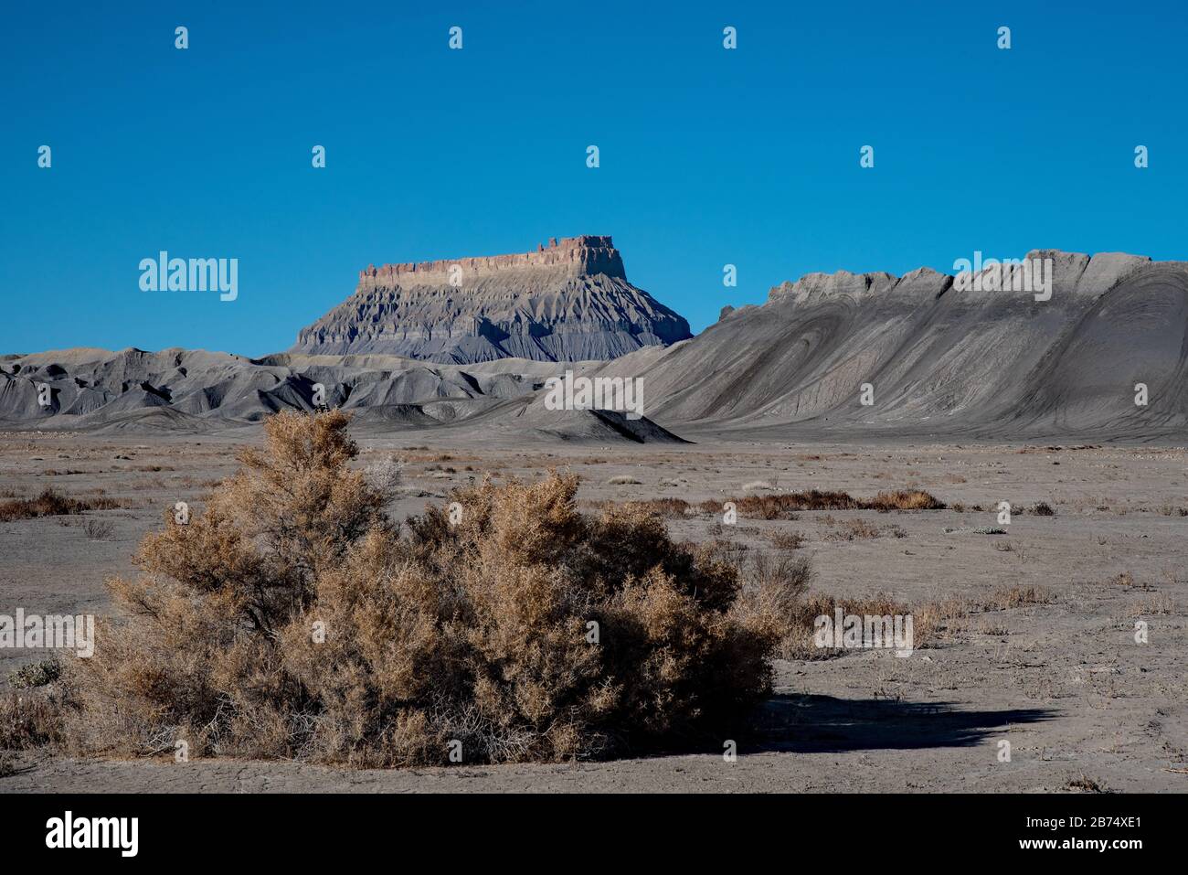Factory Butte near Cainesville, Utah, USA.  This rugged badland area is often described as a 'moonscape.' Factory Butte is a prominent feature. Stock Photo