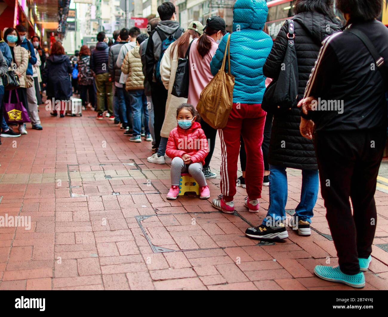 Hong Kongers line up to buy surgical masks in Hong Kong. The first person in the line said he started to line up at 3 am in the morning. A thirty-nine year old man in Hong Kong believed to have been the first victim of the Coronavirus. Stock Photo