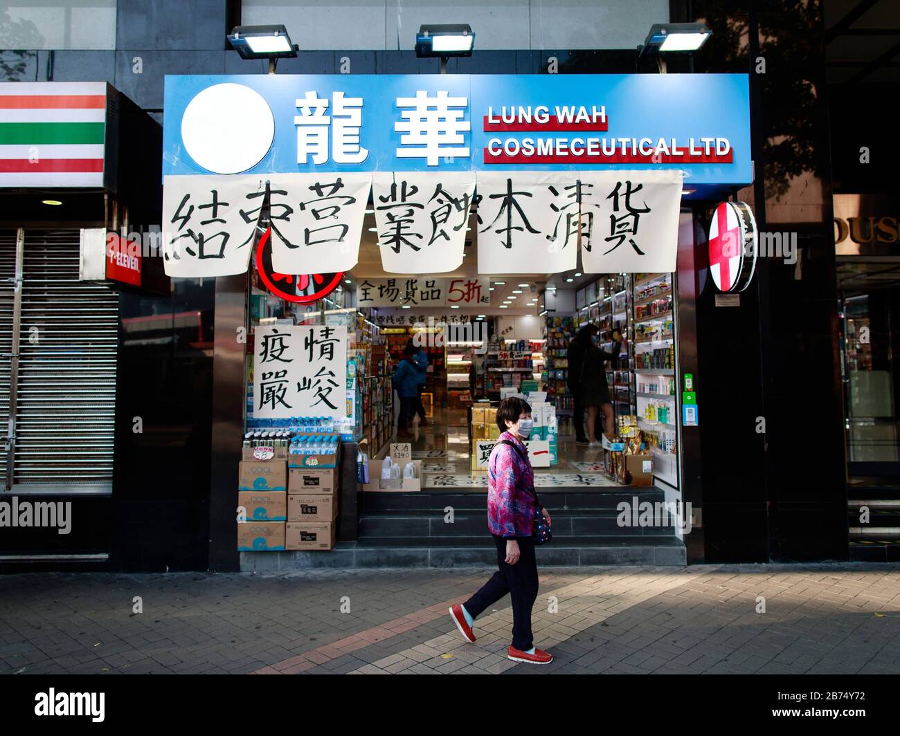 A woman walks in front shop which will soon to be closed down in Tsim Sha Tsui of Hong Kong. Stock Photo