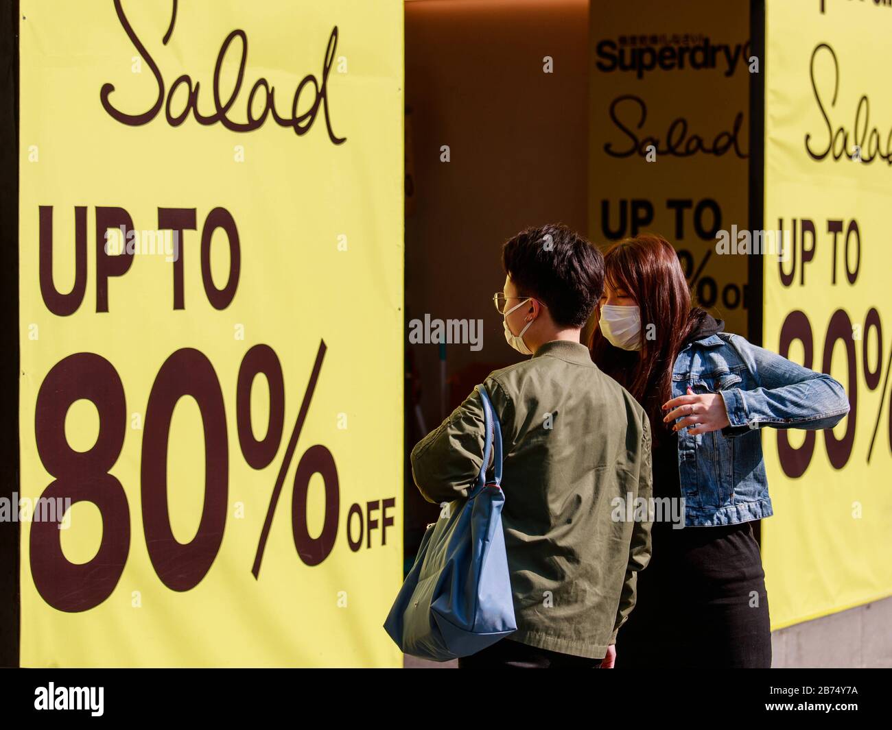 People walk in front of a shop which shows 80% off in Tsim Sha Tsui of Hong Kong. Stock Photo