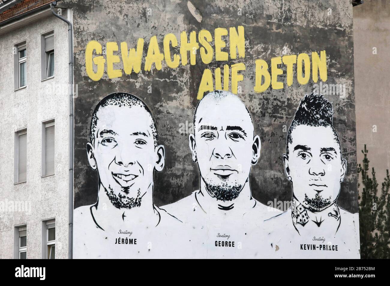 On a wall of a house in Berlin's Wedding district, a picture of the brothers Jérôme Boateng, George Boateng and Kevin-Prince Boateng can be seen. The mural 'Grown on Concrete' is located in the district of Wedding and symbolizes the career of the three Boateng brothers and the history of their soccer field in Wedding The graffiti with the inscription was applied by Nike. [automated translation] Stock Photo