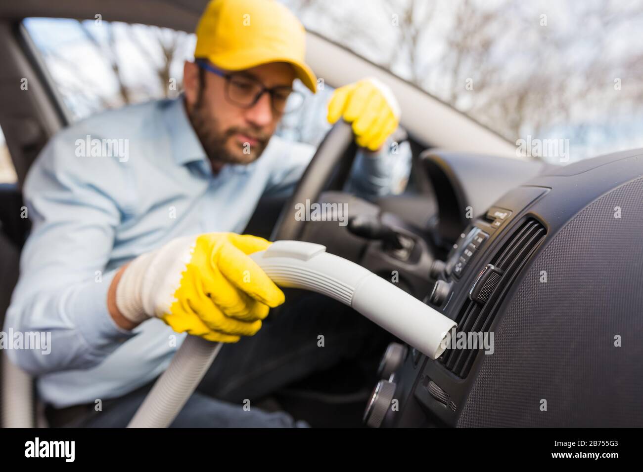 Professional handyman vacuuming car interior by using vacuum cleaner Stock Photo Alamy