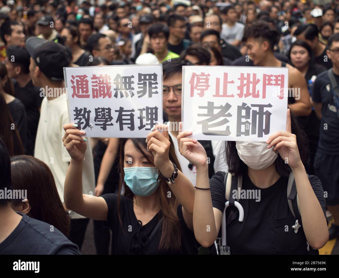 About 230,000 protesters march against the extradition bill in the touristic area of Kowloon in Hong Kong. Some protesters hand out pamplets to Mainland Chinese tourist to explain their causes and idea. The Chinese characters read:'Liberal Studies was not at fault, stop persecuting teacher'. Stock Photo