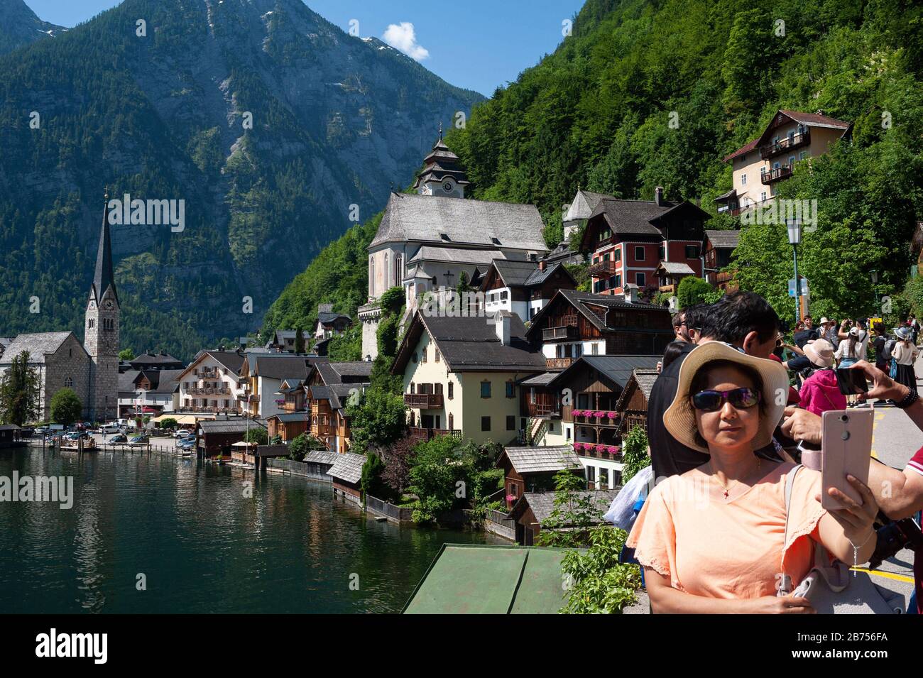 18.06.2019, Hallstatt, Salzkammergut, Upper Austria, Austria, Europe - Chinese tourists take pictures at Lake Hallstatt with a mountain panorama in the background. The small town is a favorite travel destination of Chinese and exists as a replica in the Guangdong province in China. [automated translation] Stock Photo