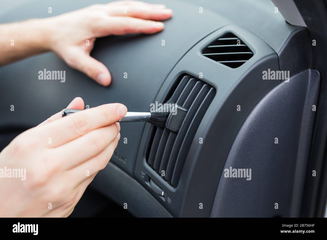 Close Businessman Hand Tuning Air Ventilation Grille While Driving