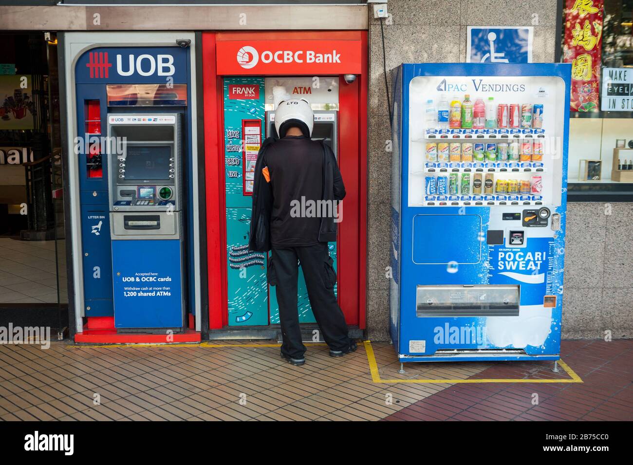 22.02.2018, Singapore, Republic of Singapore, Asia - A man withdraws money from an ATM in downtown Singapore. [automated translation] Stock Photo