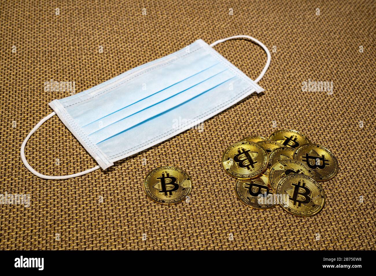 Gold Bitcoin coins with a medical mask. A business finance concept Stock Photo