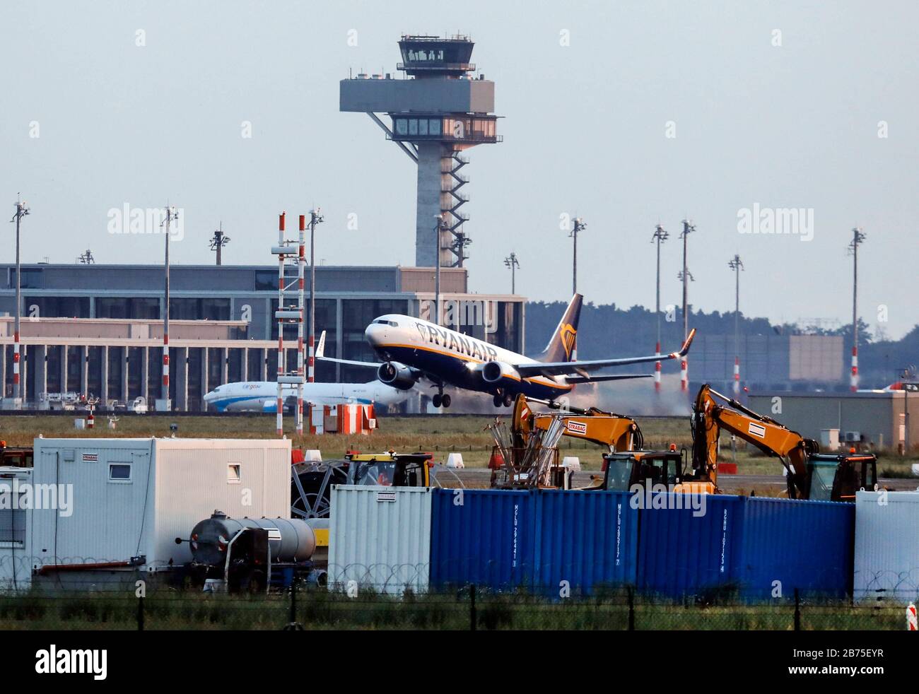 https://c8.alamy.com/comp/2B75EYR/a-boeing-737-of-the-airline-ryanair-will-take-off-from-schoenefeld-airport-the-runway-passes-the-construction-site-of-ber-airport-berlin-brandenburg-in-the-background-you-can-see-the-new-tower-of-ber-der-ber-is-scheduled-to-open-in-2020-after-many-postponements-of-the-opening-date-automated-translation-2B75EYR.jpg