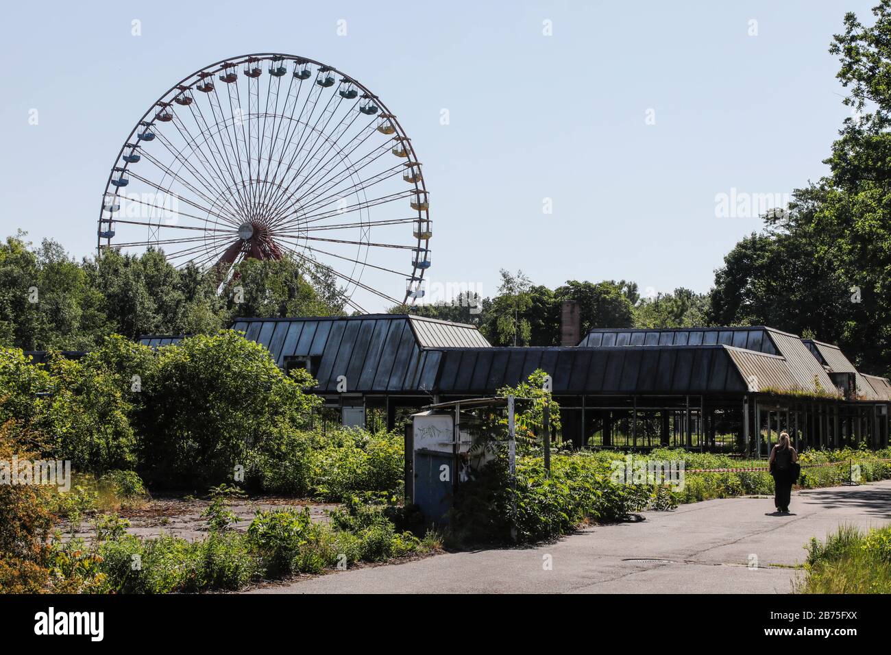 View of the rusting Ferris wheel in the former Spreepark in the Berlin Plaenterwald, in the foreground the abandoned restaurant building. In GDR times the playground was a well visited amusement park. Gruen Berlin GmbH will redesign the park. [automated translation] Stock Photo