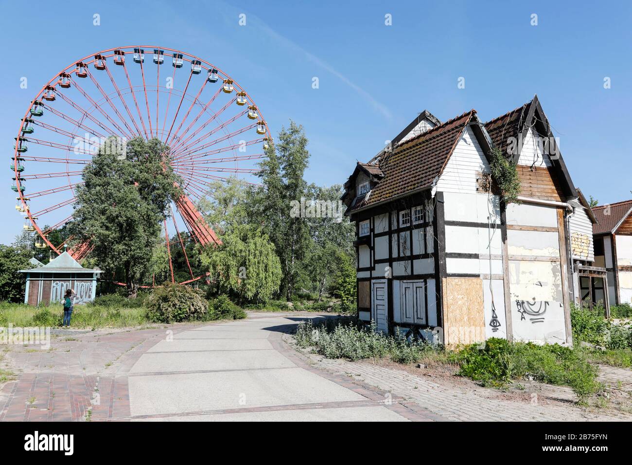 View of the rusting Ferris wheel in the former Spreepark in the Berlin Plaenterwald, in the foreground are dummies of houses. In GDR times the playground was a well visited amusement park. Gruen Berlin GmbH will redesign the park. [automated translation] Stock Photo