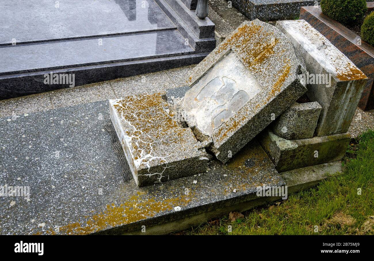 old stone grave with fallen and broken massif tombstone at a cemetery Stock Photo