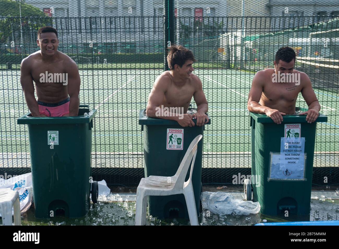 04.11.2017, Singapore, Republic of Singapore, Asia - After a game at the Rugby Sevens Tournament, three players of the Australian rugby team Casuarina Cougars cool down in garbage cans filled with ice water.     Use for editorial purposes only [automated translation] Stock Photo