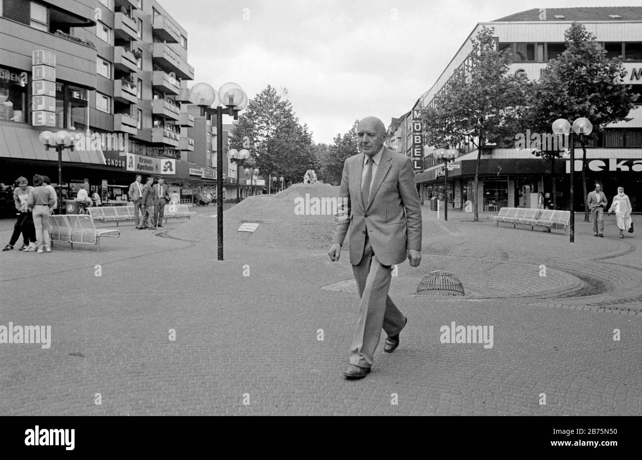 A man in a suit walks down a shopping street in Gelsenkirchen, June 18, 1984. [automated translation] Stock Photo